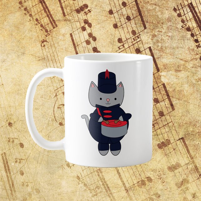Mug Marching Band Snare Drum Cat Navy Blue Red (A mug with a gray cat playing the snare drum in a red and navy blue marching band uniform.)