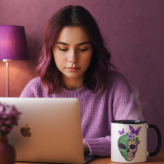 Mug Taza blanca con diseño calavera alien y mariposa – (Una joven mirando sus cosas en el ordenador mientras se toma una bebida caliente en su taza favorita)