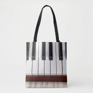 musical notes on the background of a pianoacoustic tote bag