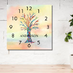 Name Monogram Rainbow Tree Square Wall Clock<br><div class="desc">This colourful Wall Clock is decorated with a mosaic tree in the colours of the rainbow on a watercolor background.
Easily customizable with your name or monogram.
Because we create our own artwork you won't find this exact image from other designers.
Original Mosaic and Watercolor © Michele Davies.</div>
