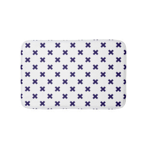 Navy blue cross stitches on white bath mat
