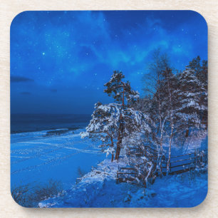Nighttime winter scene with snow covered pines coaster