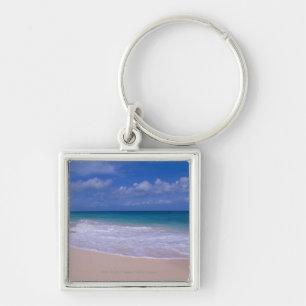 Ocean waves foaming onto sandy beach keychain