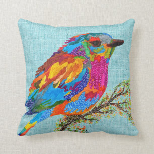 Oiseau mignon et coloré sur un oreiller à branches