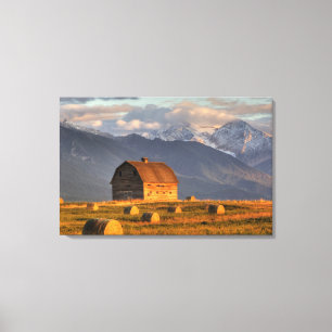 Old barn framed by hay bales and dramatic canvas print