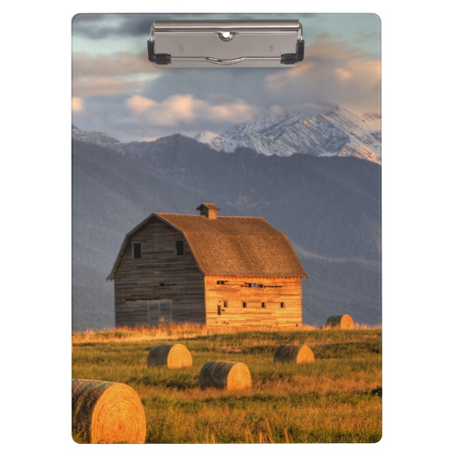 Old barn framed by hay bales and dramatic clipboard (Front)
