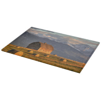 Old barn framed by hay bales and dramatic cutting board