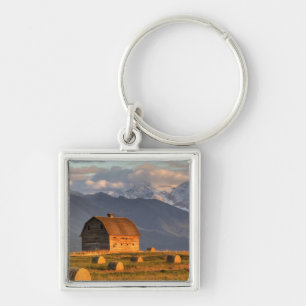 Old barn framed by hay bales and dramatic keychain