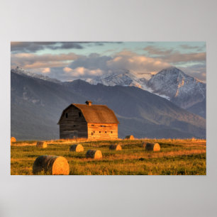 Old barn framed by hay bales and dramatic poster