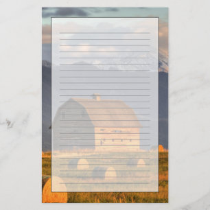 Old barn framed by hay bales and dramatic stationery