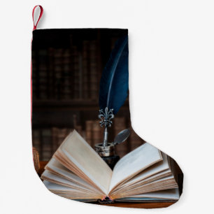 Old books, quill pen and vintage inkwell on wooden small christmas stocking