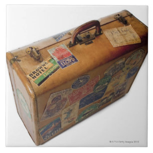 old fashioned suitcase with travel stickers tile