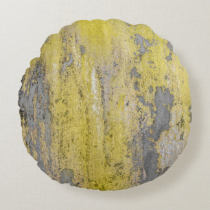 Old grey concrete wall with peeling yellow paint. round pillow