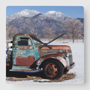 Old truck sitting in the field square wall clock