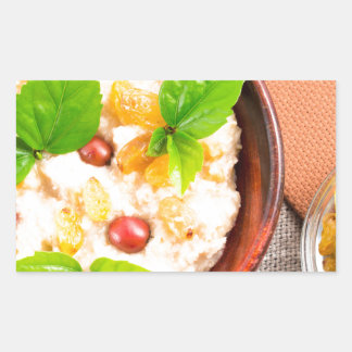 Old wooden bowl of healthy oatmeal with berries sticker