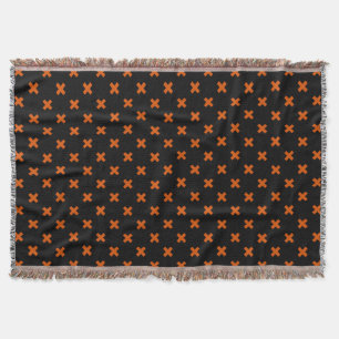 Orange cross stitches on black throw blanket