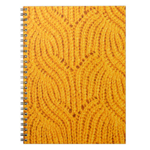 Orange knitted sweater, textured background. notebook