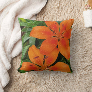 Orange-red flowers with green leaves throw pillow