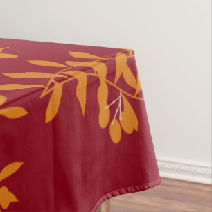 Orange silhouette branch leaves on red tablecloth