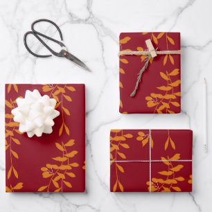 Orange silhouette branch leaves on red wrapping paper sheet