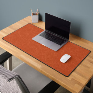 Orange textured surface with swirling pattern desk mat
