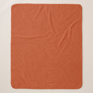 Orange textured surface with swirling pattern sherpa blanket