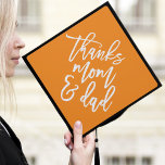 Orange | Thanks Mom and Dad Graduation Cap Topper<br><div class="desc">Thank your parents for their support by wearing a custom graduation cap topper in their honour. The stylish graduation cap topper features "Thanks Mom and Dad" in a trendy modern script font against an orange background.</div>