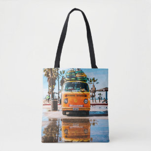 Orange van with surfboard on top tote bag