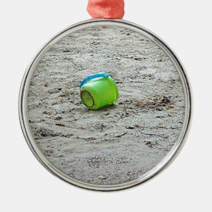 Ornement Rond Argenté Bouche verte perdue dans le sable sur la plage d'é