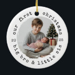 Our First Christmas – Big Bro & Little Sis Round P Ceramic Ornament<br><div class="desc">Celebrate their first holiday together with a sweet sibling keepsake. This white round ceramic ornament features a curved “our first christmas” headline and “big bro & little sis” along the bottom, a brush-stroke photo window, and split year numerals at the sides. The clean black-and-white typography and soft painted edge highlight...</div>