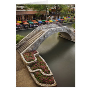 Outdoor cafe along River Walk and bridge over