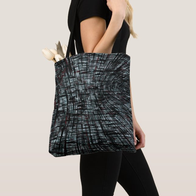 Overlapping narrow, linear cutouts intersecting on tote bag (Close Up)