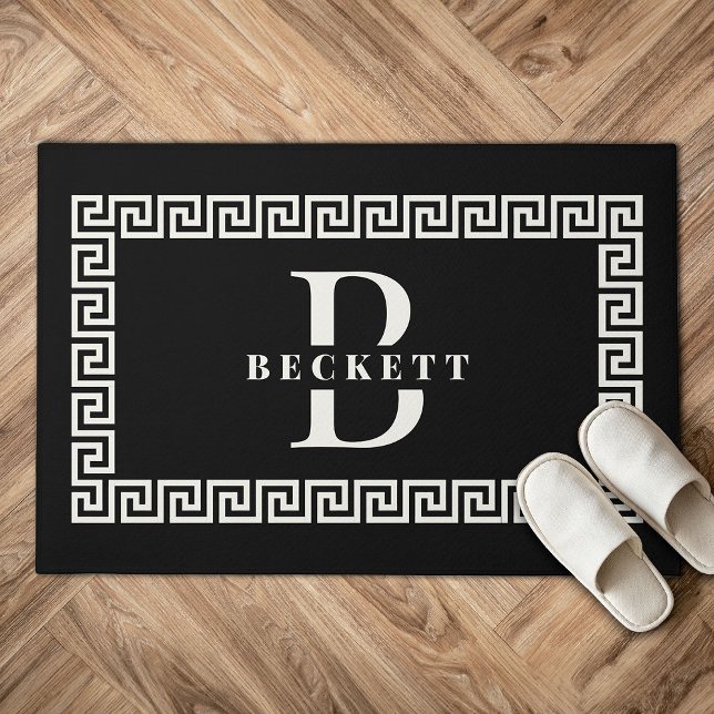 Paillasson Monogramme de cadre de clé grecque noire moderne é (Black doormat with a Greek key border, featuring the large letter "B" and "BECKETT" in white. )