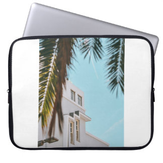 Palm tree near white concrete building laptop sleeve