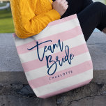 Pastel Pink and White Stripes Blue Team Bride Tote Bag<br><div class="desc">All-Over-Print Tote bag featuring the words "Team Bride" in blue trendy script against a pastel pink and white stripes pattern background. Perfect for weddings for bridesmaids, maid of honour and flower girl. For other colours and matching items see here https://www.zazzle.com/collections/119250194970828530?rf=238364477188679314 Personalize it by replacing the placeholder text. For more options...</div>