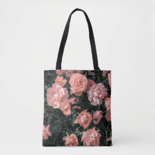 Pastel pink roses growing in the garden in soft li tote bag