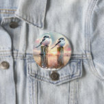 Pastel Watercolor Birds Fencepost Sunset 3 Inch Round Button<br><div class="desc">Soft watercolor brushwork captures two fluffy songbirds resting on weathered fence posts as a glowing sunset spreads across a dreamy countryside sky. Gentle washes of peach, blush pink, pale blue, and warm gold blend into a tranquil horizon, creating a calm pastoral atmosphere. The birds appear round and feathery, their delicate...</div>