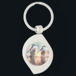 Pastel Watercolor Birds Fencepost Sunset Keychain<br><div class="desc">Soft watercolor brushwork captures two fluffy songbirds resting on weathered fence posts as a glowing sunset spreads across a dreamy countryside sky. Gentle washes of peach, blush pink, pale blue, and warm gold blend into a tranquil horizon, creating a calm pastoral atmosphere. The birds appear round and feathery, their delicate...</div>
