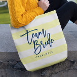 Pastel Yellow and White Stripes Blue Team Bride Tote Bag<br><div class="desc">All-Over-Print Tote bag featuring the words "Team Bride" in blue trendy script against a pastel yellow and white stripes pattern background. Perfect for weddings for bridesmaids, maid of honour and flower girl. For other colours and matching items see here https://www.zazzle.com/collections/119250194970828530?rf=238364477188679314 Personalize it by replacing the placeholder text. For more options...</div>