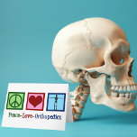 Peace Love Orthopedics Holiday Card<br><div class="desc">Peace Love Orthopedics present. A cute Christmas gift for an orthopaedic surgeon or orthopedist who works with the musculoskeletal system and patients who need shoulder and hip surgery. A peace sign,  heart,  and a skeleton to show the bones of the specialty.</div>