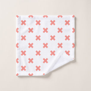 Peach cross stitches on white wash cloth