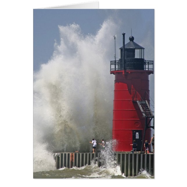 People on jetty watch large breaking waves in (Front)