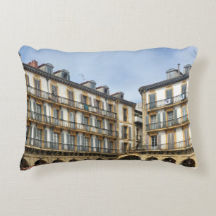 PEOPLE WALKING NEAR BEIGE CONCRETE BUILDING DURING ACCENT PILLOW