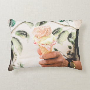 Person holding ice cream cone with three flavours accent pillow