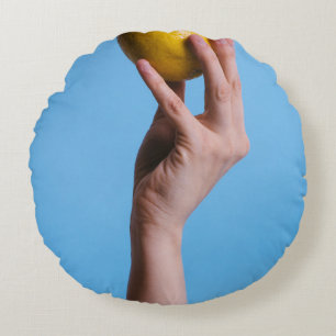 Person holding lemon round pillow