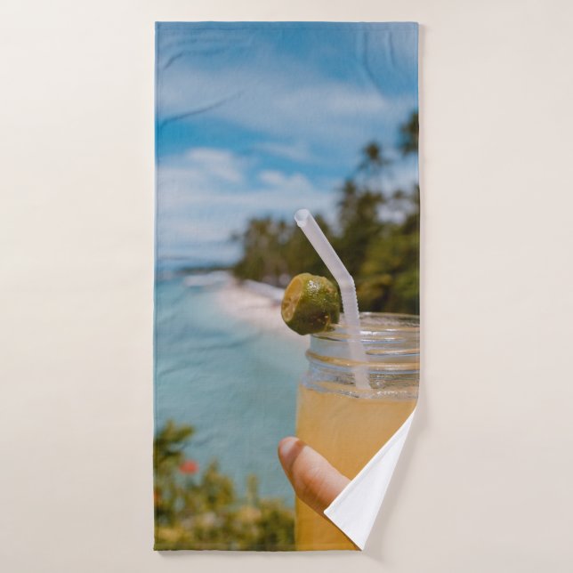 Person holding mason jar with filled with juice at bath towel (Bath Towel)