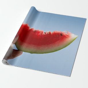 Person holding sliced watermelon wrapping paper