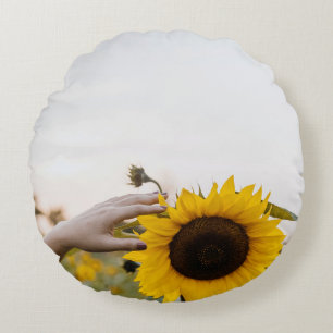 Person holding sunflower round pillow