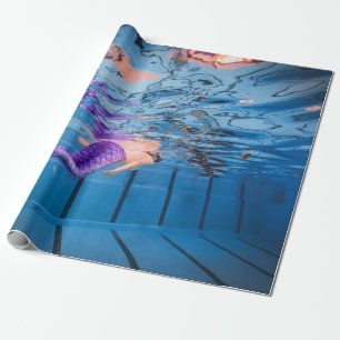 Person in purple pants lying on blue hammock wrapping paper