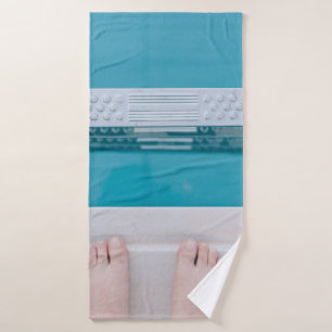Person standing on swimming pool ladder bath towel